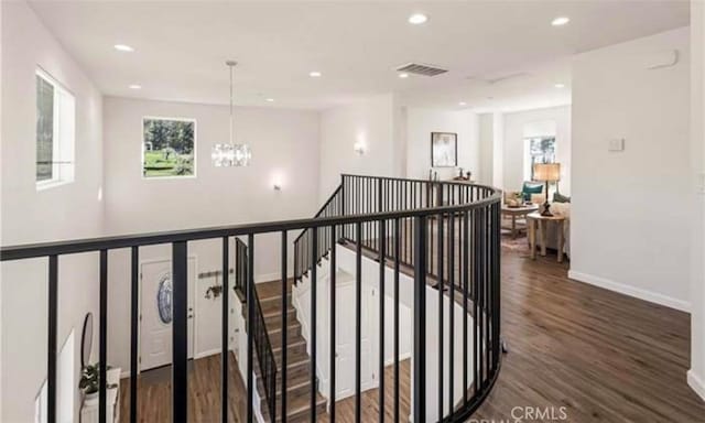 hallway with an inviting chandelier and dark hardwood / wood-style floors