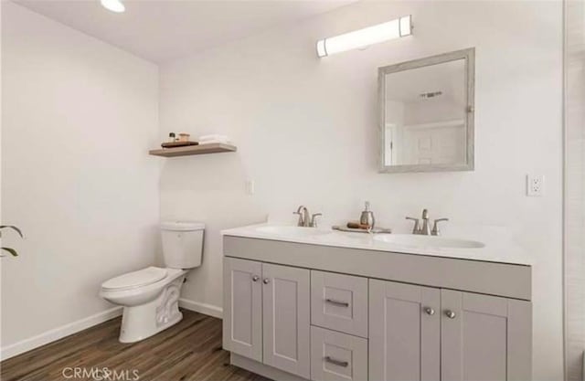 bathroom featuring hardwood / wood-style flooring, vanity, and toilet