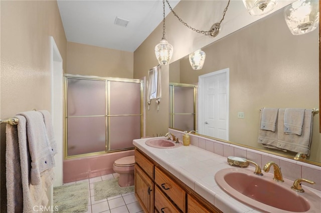 full bathroom with vanity, bath / shower combo with glass door, toilet, and tile patterned flooring