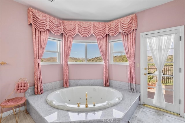 bathroom featuring tiled tub