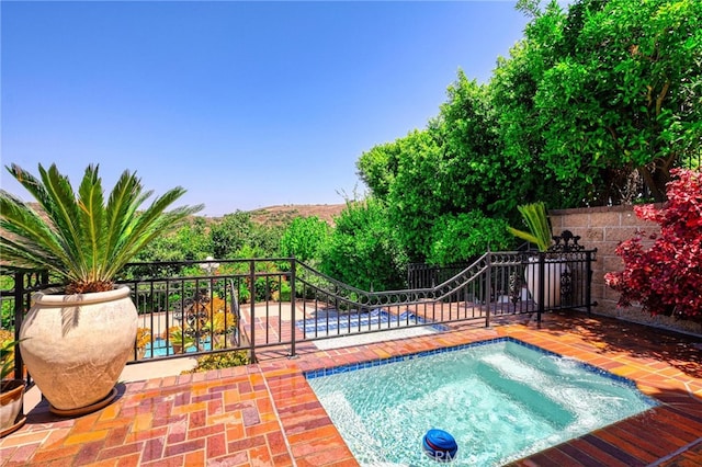 view of swimming pool featuring an in ground hot tub