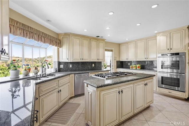 kitchen featuring a wealth of natural light, appliances with stainless steel finishes, sink, and a center island