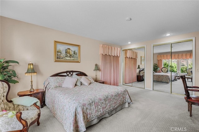 bedroom featuring two closets and light colored carpet