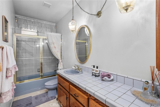 full bathroom featuring vanity, toilet, combined bath / shower with glass door, and tile patterned flooring