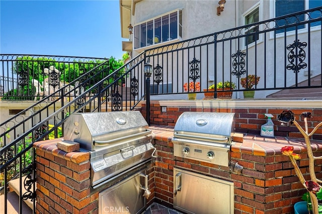 view of patio with exterior kitchen and a grill