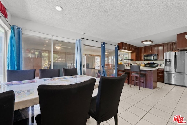 tiled dining room with a textured ceiling