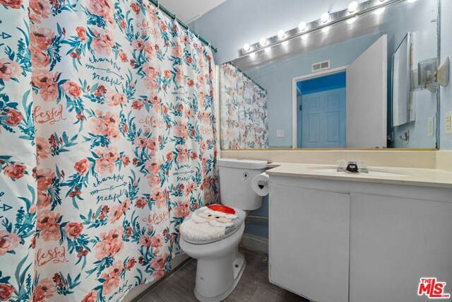 bathroom featuring a shower with curtain, vanity, hardwood / wood-style floors, and toilet