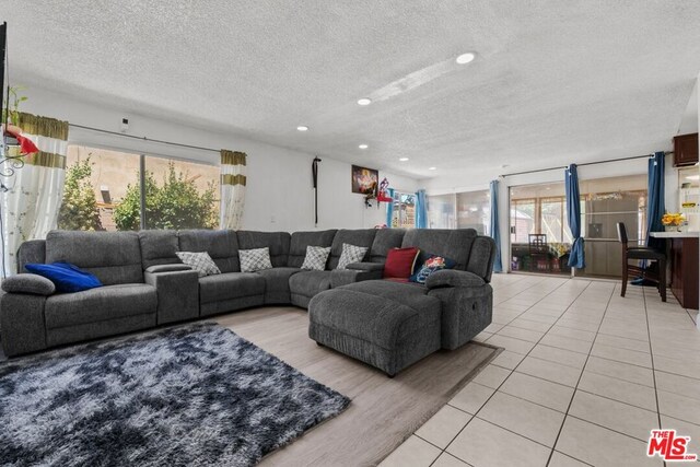 living room featuring a textured ceiling and light tile patterned floors