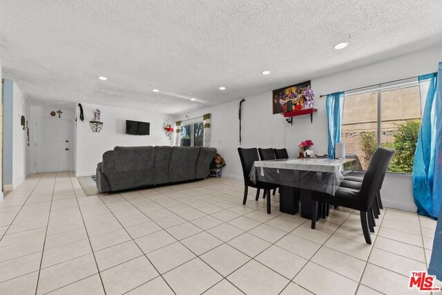 dining room with a textured ceiling and light tile patterned flooring