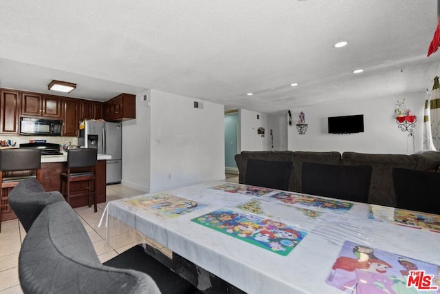 dining area featuring light tile patterned floors and a textured ceiling