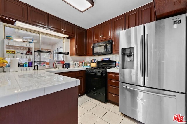 kitchen featuring tile counters, decorative backsplash, kitchen peninsula, black appliances, and light tile patterned floors