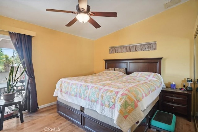 bedroom with vaulted ceiling, light hardwood / wood-style flooring, and ceiling fan