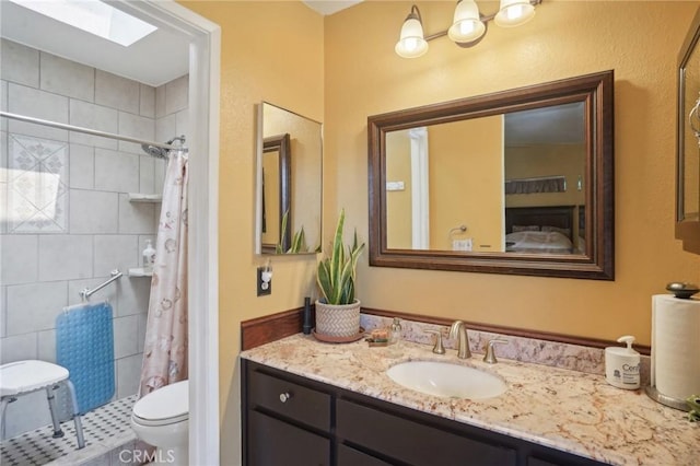 bathroom with a skylight, a shower with curtain, vanity, and toilet