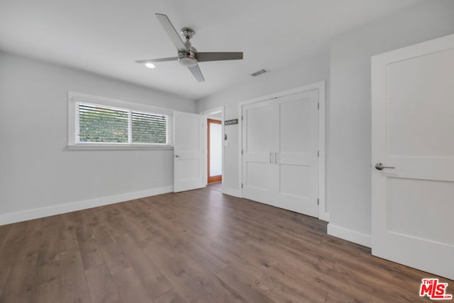 unfurnished bedroom featuring dark wood-type flooring and ceiling fan