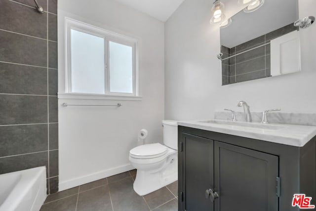 full bathroom featuring tile patterned flooring, tiled shower / bath combo, vanity, and toilet