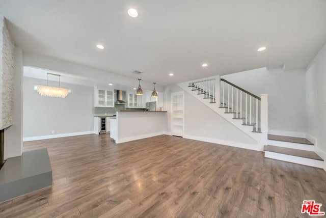 unfurnished living room with a chandelier, dark hardwood / wood-style floors, and wine cooler