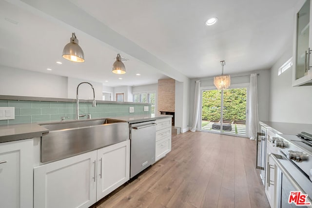 kitchen with tasteful backsplash, white cabinets, light hardwood / wood-style flooring, range with electric stovetop, and stainless steel dishwasher