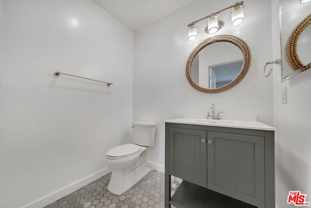 bathroom with vanity, tile patterned flooring, and toilet