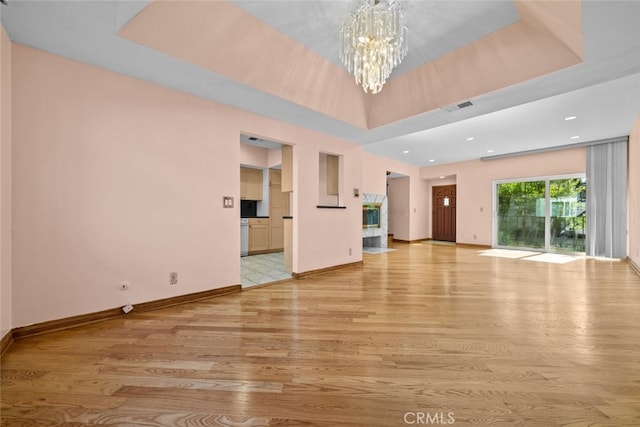 unfurnished living room with light hardwood / wood-style floors and a chandelier