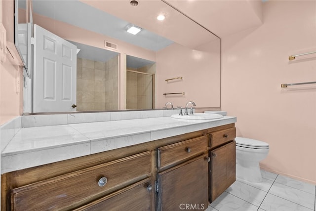 bathroom featuring a shower with shower door, vanity, and toilet