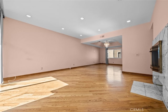 unfurnished living room featuring light wood-type flooring and a high end fireplace