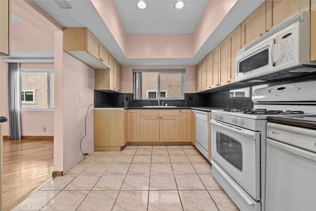 kitchen with white appliances, light brown cabinets, and light tile patterned flooring