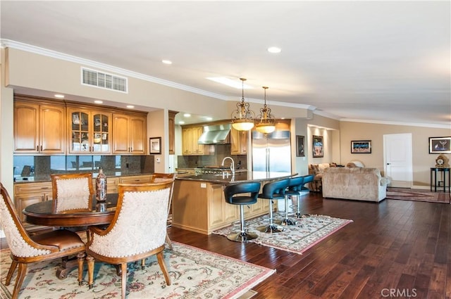 dining area with sink, ornamental molding, and dark hardwood / wood-style floors