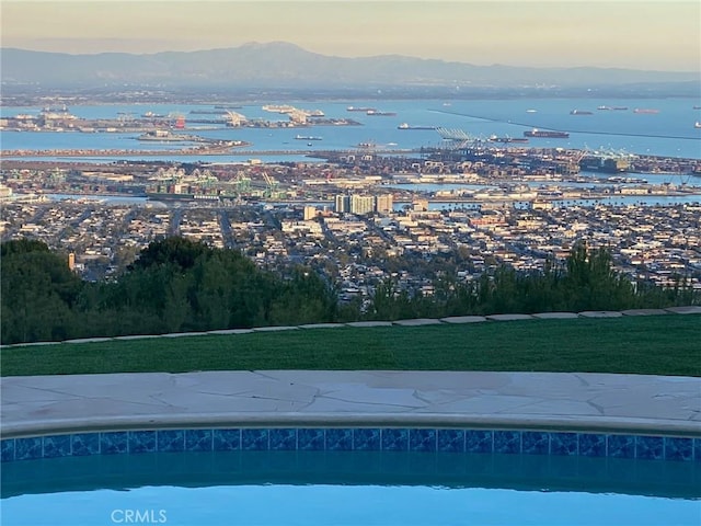 pool at dusk with a water and mountain view