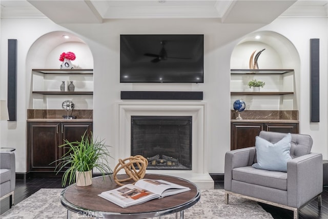 living room featuring built in shelves, ornamental molding, and dark hardwood / wood-style flooring