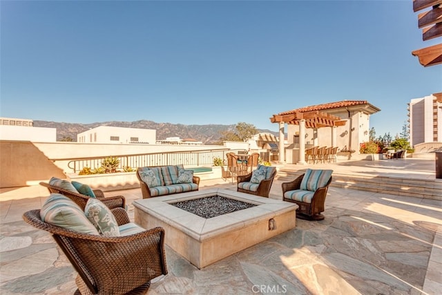 view of patio with a mountain view and a fire pit