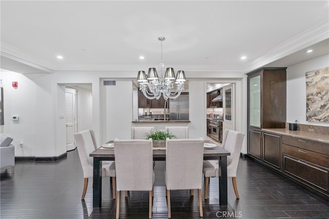 dining area with ornamental molding, a chandelier, and dark hardwood / wood-style flooring