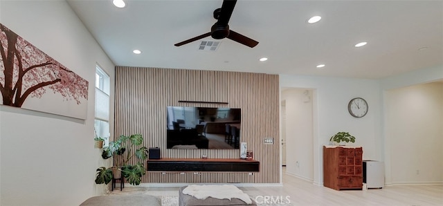 living room featuring light hardwood / wood-style floors and ceiling fan