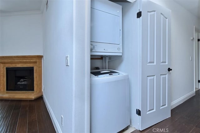 laundry room with dark hardwood / wood-style flooring, ornamental molding, and stacked washer and clothes dryer