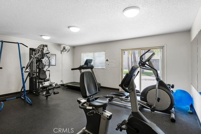 workout area featuring a wealth of natural light and a textured ceiling