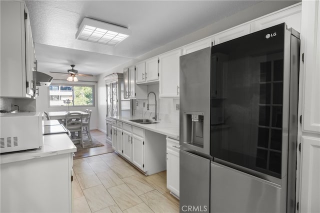 kitchen with white cabinetry, sink, appliances with stainless steel finishes, and tasteful backsplash