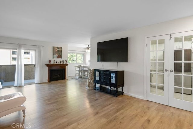 living room featuring ceiling fan, light wood-type flooring, and french doors