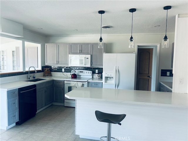 kitchen featuring gray cabinets, sink, hanging light fixtures, decorative backsplash, and white appliances