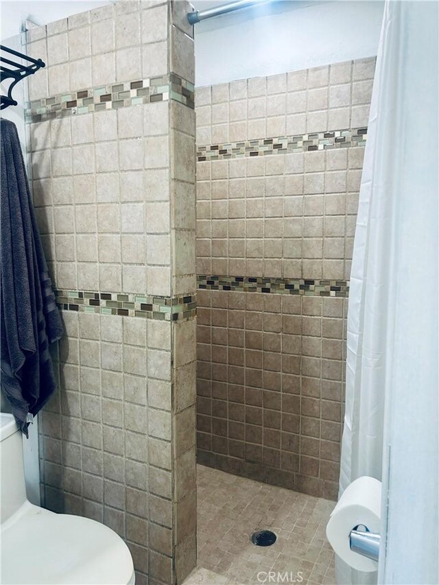 bathroom with toilet and a shower with curtain