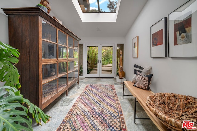 living area with french doors and vaulted ceiling with skylight