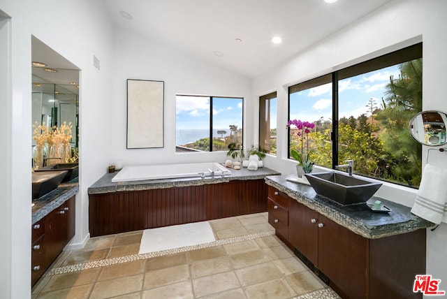 bathroom with vanity, lofted ceiling, a tub, and breakfast area