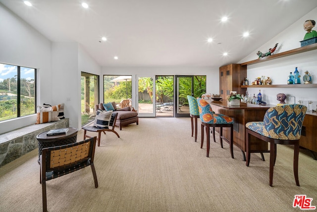 dining room with high vaulted ceiling and light colored carpet