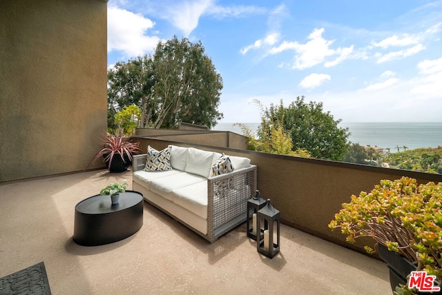 balcony featuring an outdoor living space and a water view