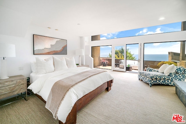 carpeted bedroom with access to exterior and a water view