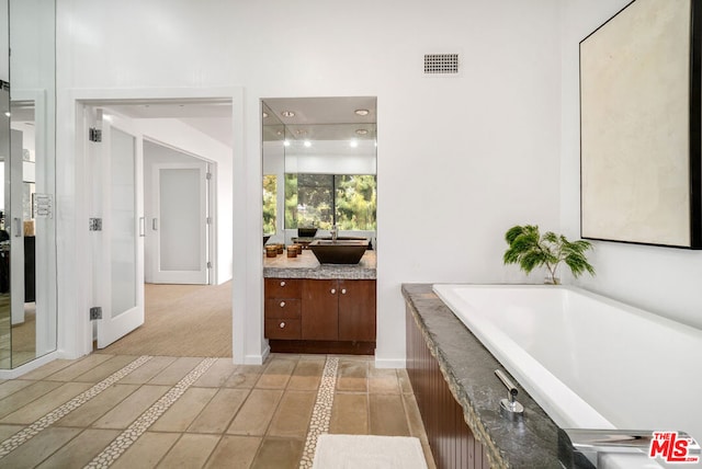 bathroom featuring vanity and a bath