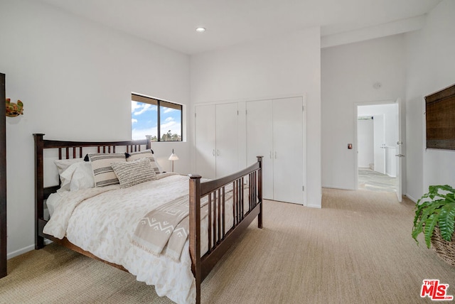 carpeted bedroom with a towering ceiling