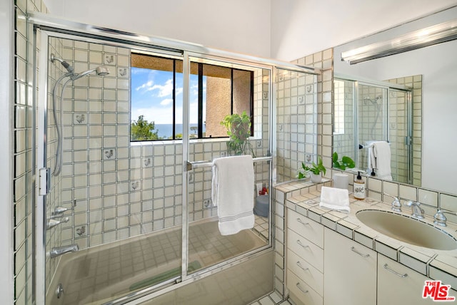 bathroom with vanity and combined bath / shower with glass door