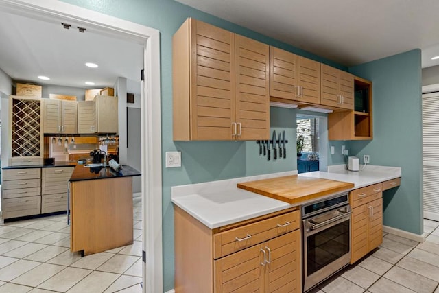 kitchen with light tile patterned flooring, stainless steel oven, and a kitchen island