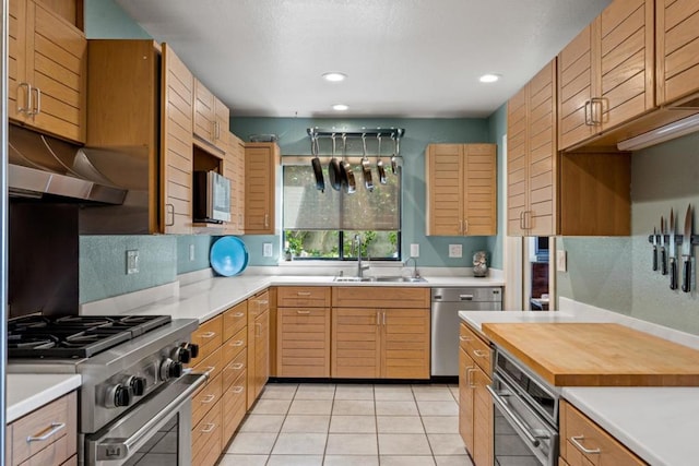 kitchen featuring butcher block countertops, sink, light tile patterned floors, and appliances with stainless steel finishes