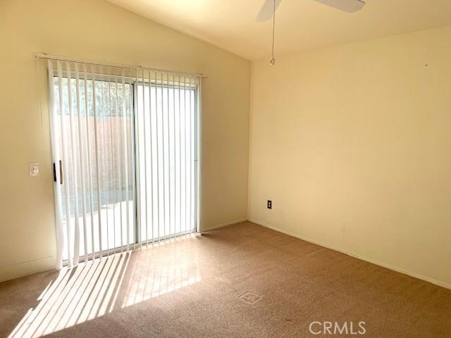 empty room featuring carpet flooring, plenty of natural light, and lofted ceiling