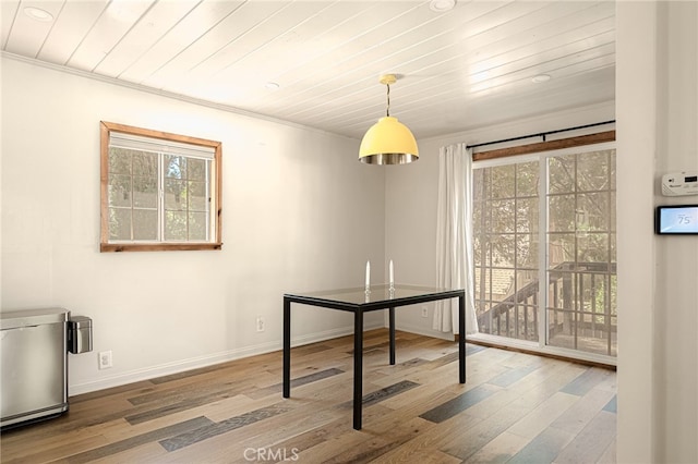 dining space featuring hardwood / wood-style flooring, ornamental molding, and wooden ceiling